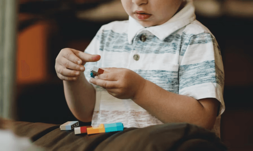 Criança brincando com blocos de montar coloridos